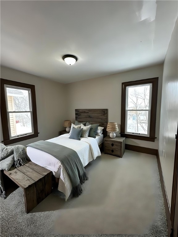 bedroom featuring light carpet and baseboards