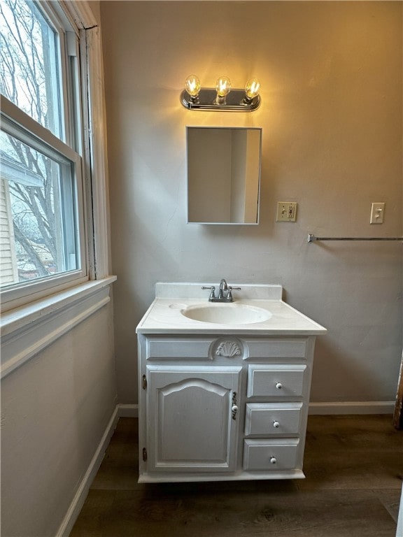 bathroom with vanity, baseboards, and wood finished floors