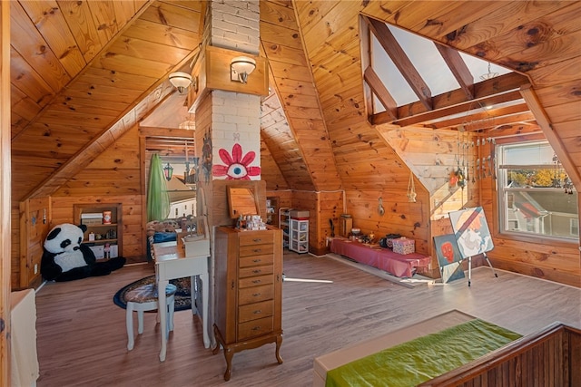 bedroom featuring vaulted ceiling with beams, wood walls, and wood finished floors