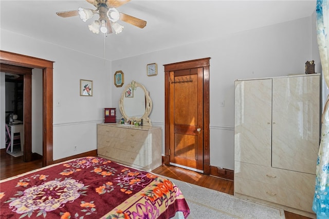 bedroom with ceiling fan, baseboards, and wood finished floors