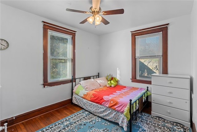 bedroom with a ceiling fan, baseboards, and wood finished floors