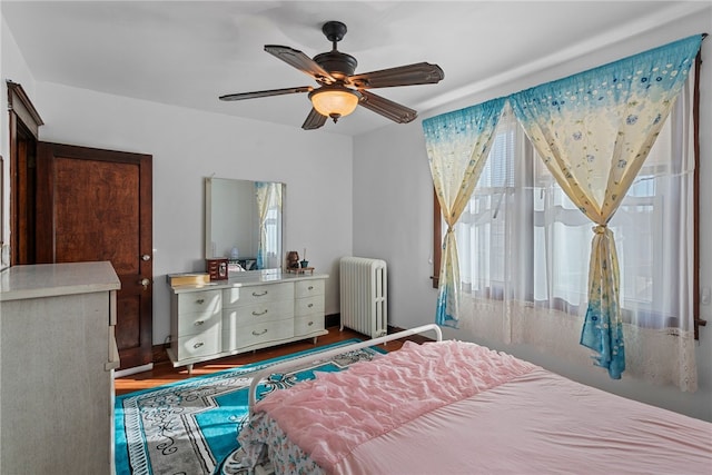 bedroom with ceiling fan, radiator heating unit, and baseboards