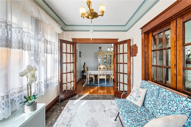 living area featuring ornamental molding, french doors, dark wood finished floors, and a notable chandelier