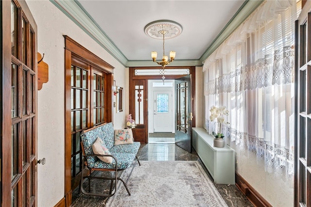 foyer with ornamental molding, a chandelier, and a textured wall