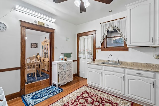 kitchen featuring pendant lighting, white cabinetry, and a sink