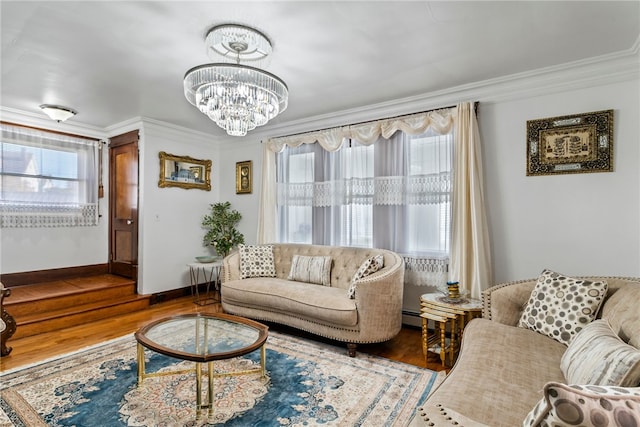 living room with baseboards, ornamental molding, wood finished floors, and a notable chandelier