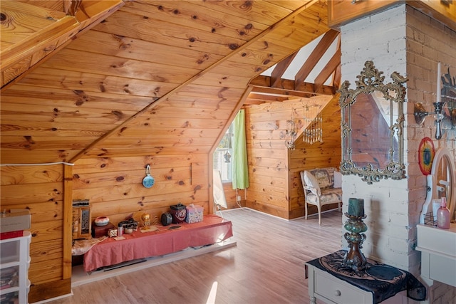 bedroom featuring vaulted ceiling, wood walls, wooden ceiling, and wood finished floors