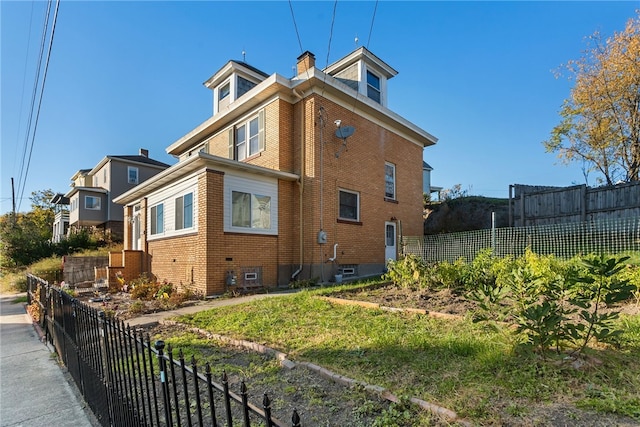 view of home's exterior featuring fence private yard, brick siding, and a chimney