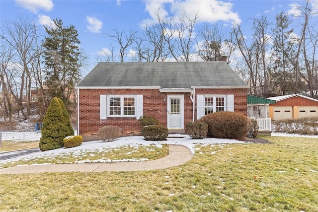 view of front facade with brick siding, a chimney, a garage, an outdoor structure, and a front lawn