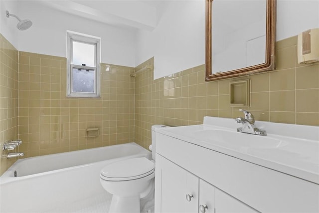 bathroom featuring toilet, washtub / shower combination, tile walls, and vanity