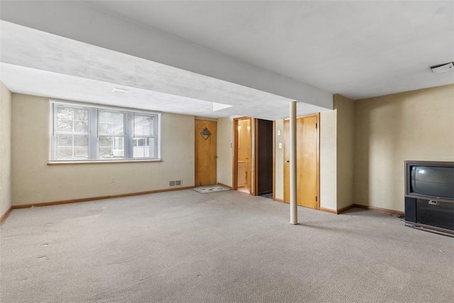 unfurnished living room with baseboards, visible vents, and light colored carpet