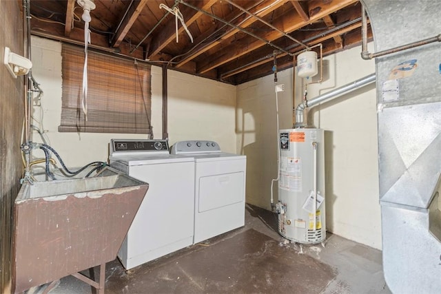 clothes washing area with laundry area, gas water heater, heating unit, washing machine and dryer, and a sink