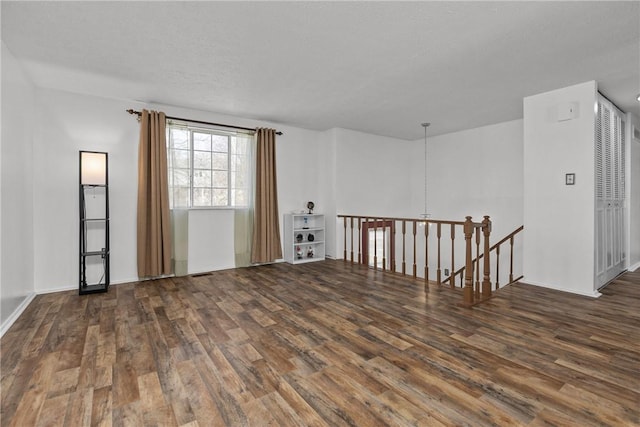 unfurnished room featuring a textured ceiling and dark wood-type flooring