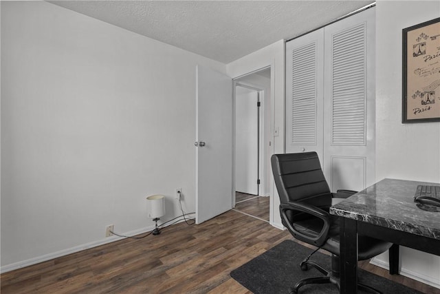 office space with dark wood-style floors, a textured ceiling, and baseboards