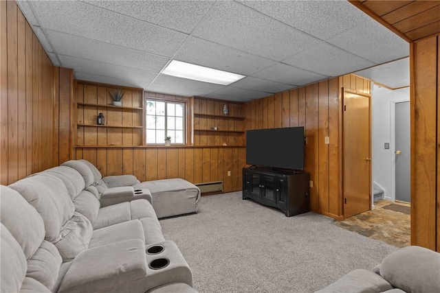 living room featuring a baseboard heating unit, light colored carpet, and wooden walls