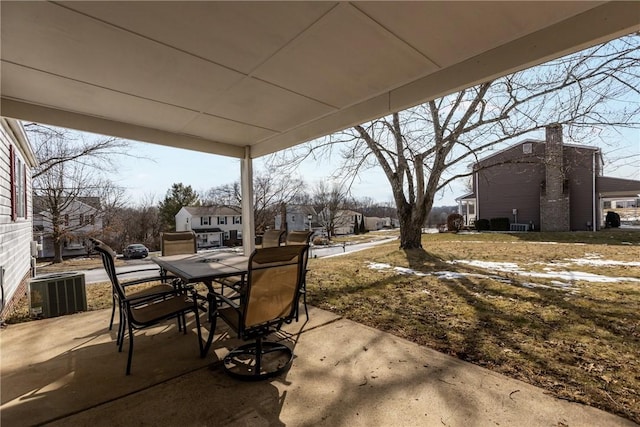 view of patio / terrace featuring a residential view, outdoor dining area, and central AC unit