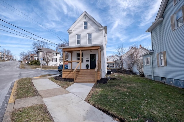 view of front of home featuring a residential view, a porch, and a front yard