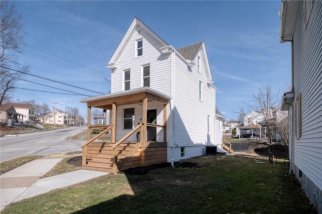 view of front of house featuring a residential view, covered porch, and a front lawn