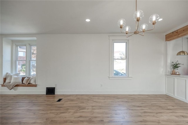 unfurnished dining area featuring light wood-style floors, visible vents, and a healthy amount of sunlight