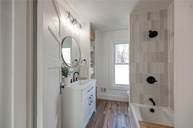 bathroom featuring shower / washtub combination, visible vents, toilet, vanity, and wood finished floors