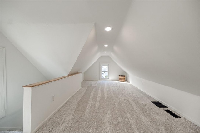 additional living space with lofted ceiling, recessed lighting, light colored carpet, visible vents, and baseboards