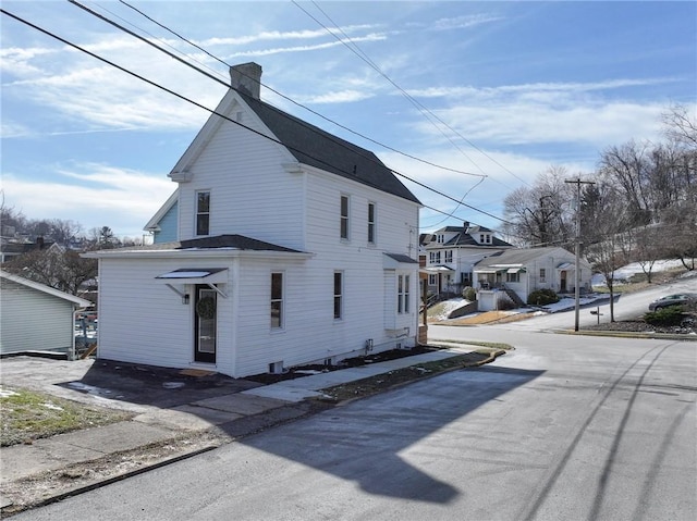 view of home's exterior with a residential view and a chimney