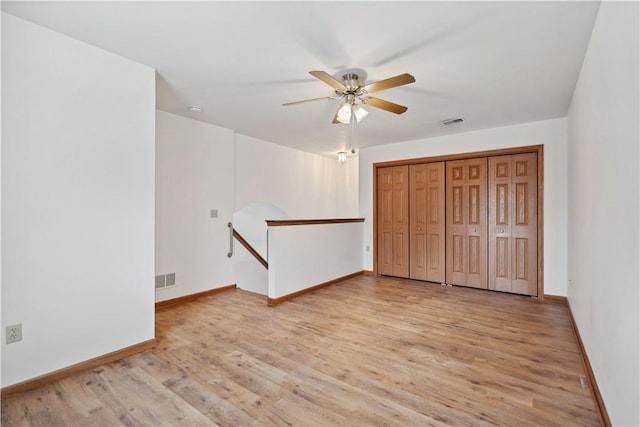 unfurnished bedroom featuring light wood finished floors, baseboards, visible vents, and a ceiling fan