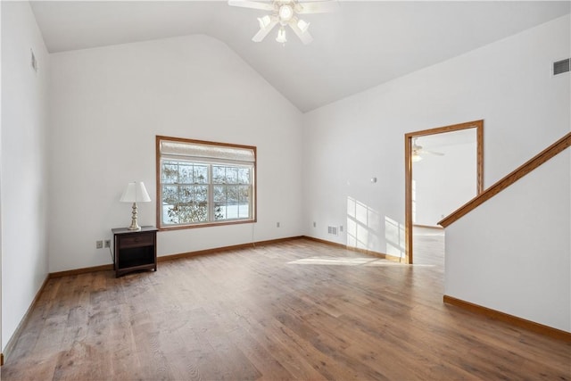 empty room featuring a ceiling fan, visible vents, baseboards, and wood finished floors