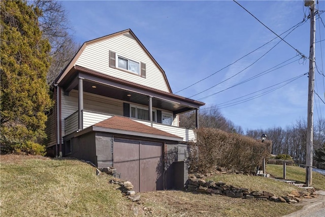 view of side of property with a yard and a gambrel roof