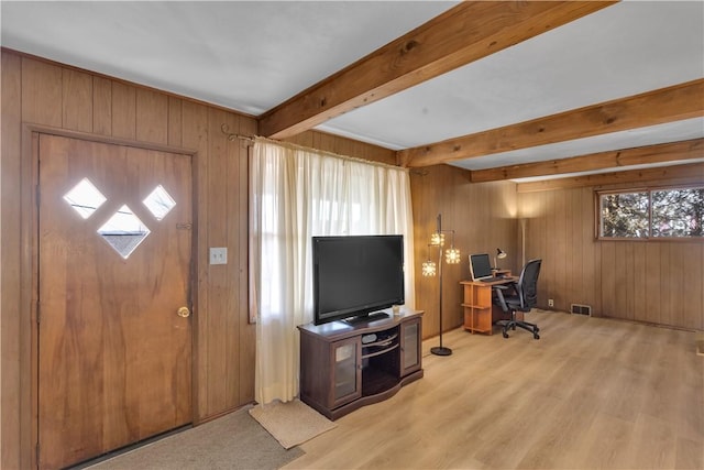 entryway featuring visible vents, wooden walls, beam ceiling, and light wood-style floors