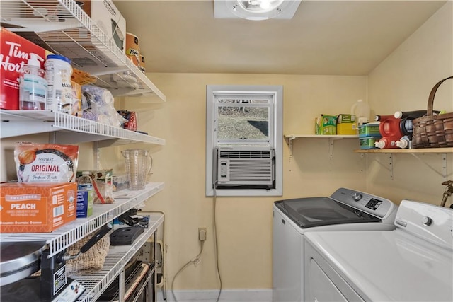 washroom with laundry area, cooling unit, washing machine and clothes dryer, and baseboards