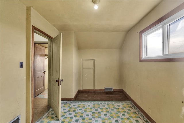 bonus room featuring lofted ceiling, visible vents, and baseboards