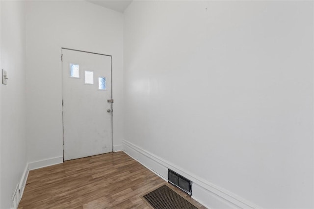 entrance foyer with wood finished floors, visible vents, and baseboards