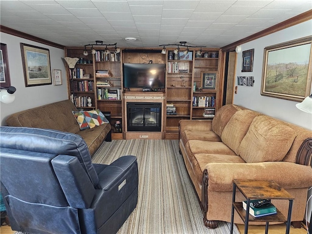 living area with a glass covered fireplace and crown molding