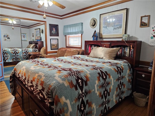 bedroom featuring ornamental molding, dark wood finished floors, and a ceiling fan