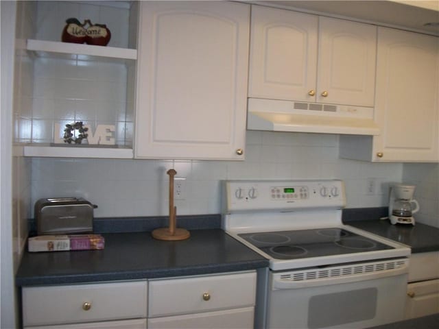 kitchen featuring dark countertops, white cabinetry, under cabinet range hood, and white electric range oven