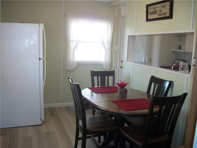 dining room with light wood-style flooring and baseboards