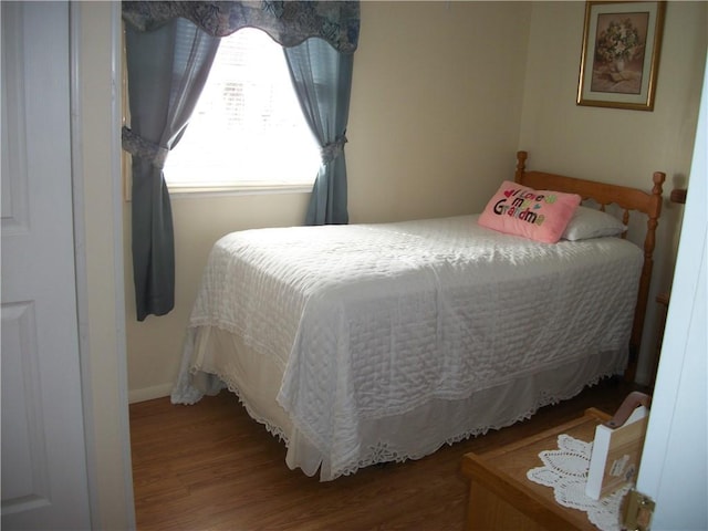 bedroom with baseboards and wood finished floors