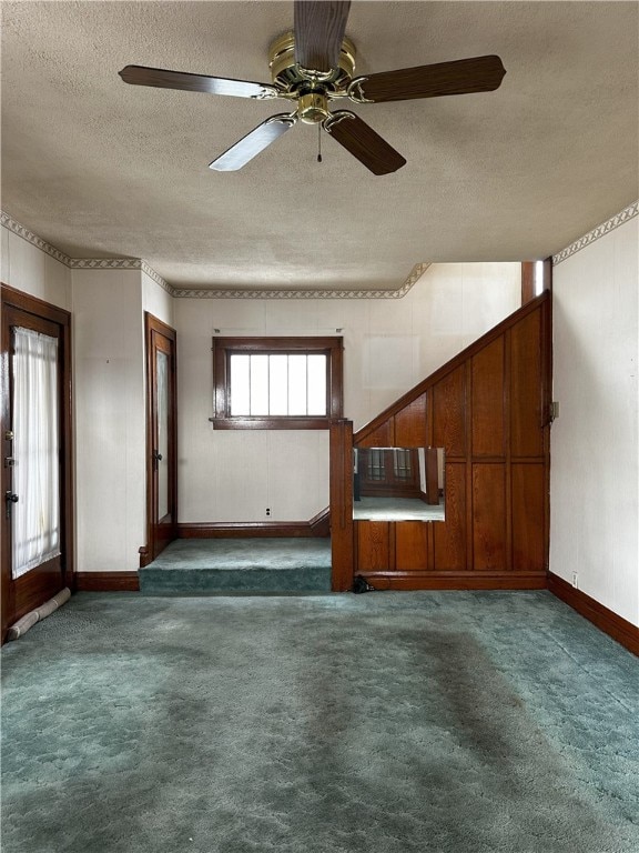 spare room with baseboards, dark colored carpet, and a textured ceiling