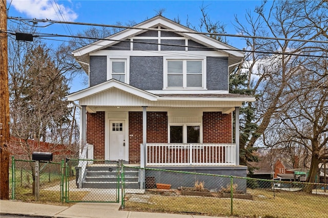 view of front of home with covered porch, brick siding, a fenced front yard, and a gate