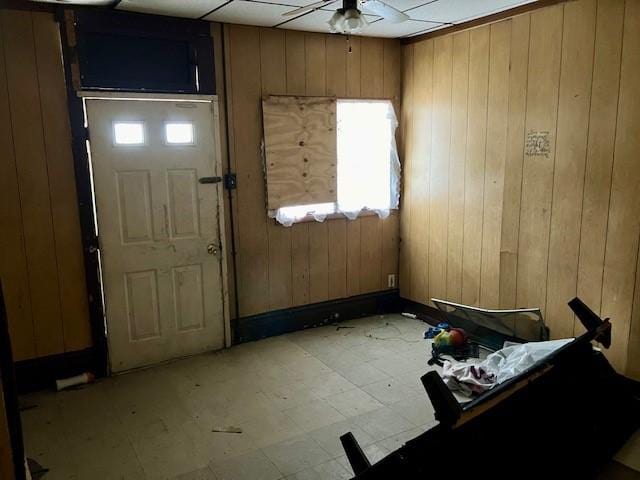 entryway with light floors and wooden walls