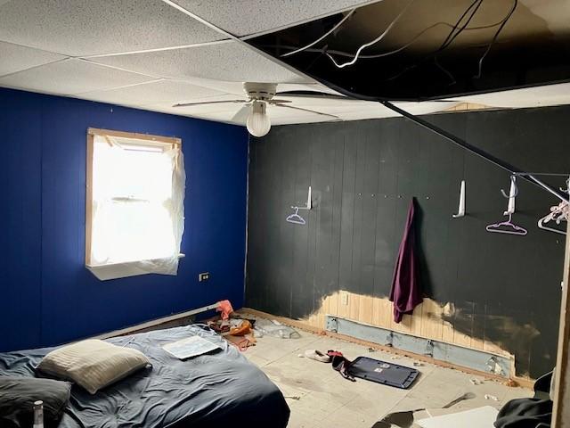 bedroom featuring a drop ceiling and ceiling fan