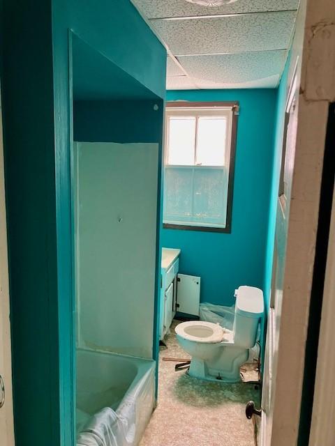 full bath featuring a paneled ceiling, vanity, toilet, and bathing tub / shower combination