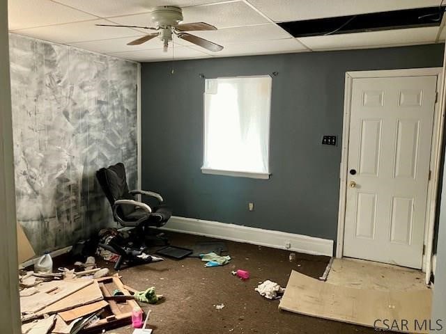 interior space featuring a ceiling fan, a paneled ceiling, and baseboards