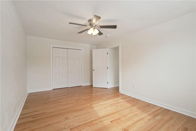 unfurnished bedroom featuring light wood-style floors, baseboards, and a closet