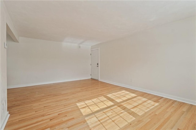 empty room with light wood-type flooring and baseboards