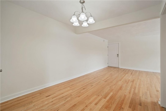 empty room with beam ceiling, an inviting chandelier, light wood-style flooring, and baseboards