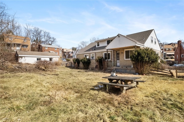 rear view of property with a yard, fence, and a residential view