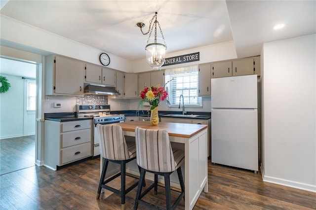 kitchen featuring range with gas stovetop, a kitchen island, freestanding refrigerator, under cabinet range hood, and a sink