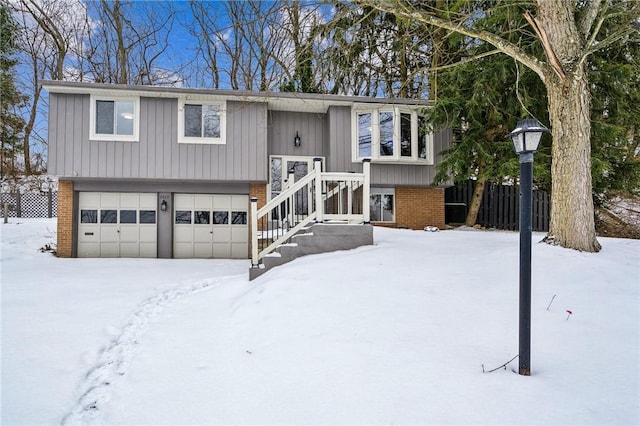 split foyer home featuring an attached garage and brick siding